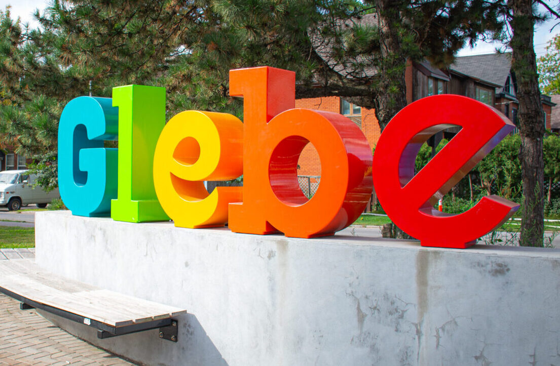 The painted GLEBE letter sign standing in a snowbank on Bank Street